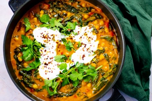 A pan with the chickpea curry and a plate with simple white rice.