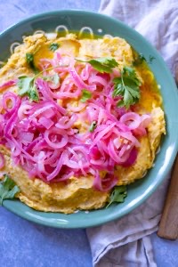 dominican mashed plantain topped with sauteed red onions 