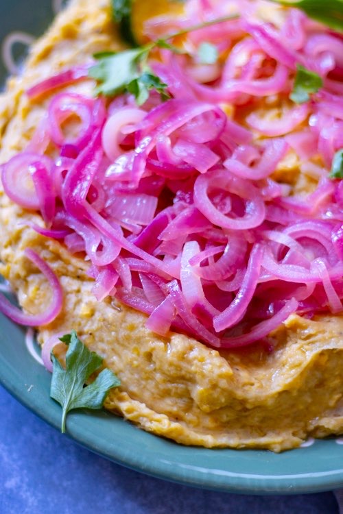 dominican mashed plantain topped with sauteed red onions 